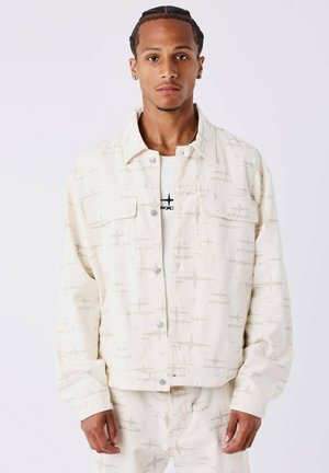 Crème-kleurige denimjack met een subtiel geometrisch patroon, knoopsluitingen, twee borstzakken en een relaxte pasvorm. Getextureerde stof.