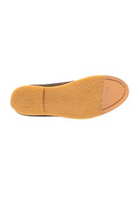 Braune Schuhsohle mit einer strukturierten, gummiartigen gelben Unterseite und einer glatten Akzentuierung im Zehenbereich, die ein glänzendes Logodetail aufweist.