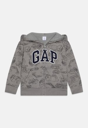 Sweat à capuche gris zippé avec des contours de véhicules de chantier et de grosses lettres bleu marine "GAP" sur la poitrine, avec poche avant et capuche.