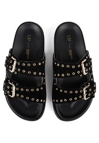 Svarta mockaskor med gyllene metallnitar, två justerbara remmar med spännen och en slät svart sula. Designade för att sättas på lätt.