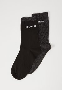 Black socks with a contrasting dark grey pair, featuring a shiny texture and "HUGO" logo in white on the cuff of each sock.