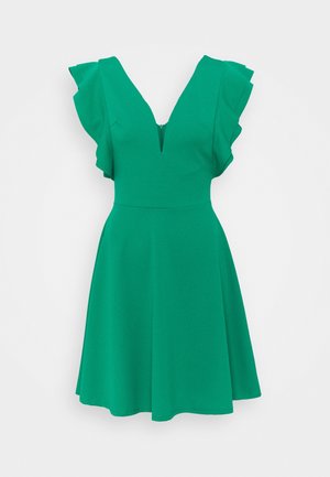 Grünes ärmelloses Kleid mit gerafften Schultern, tiefem V-Ausschnitt, tailliertem Bund und ausgestelltem Rock vor weißem Hintergrund.