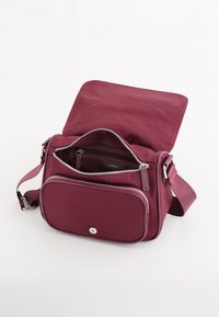 Bordeaux crossover taske lavet af blødt nylon, med en lynlåset hovedrum, frontlomme og justerbar rem.