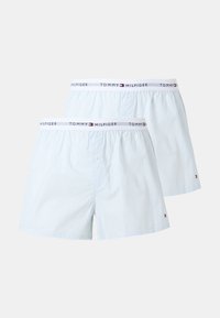 Δύο λευκά βαμβακερά μποξεράκια με λεπτές κάθετες ρίγες και ελαστικές μέσες με λογότυπα και σήματα Tommy Hilfiger.