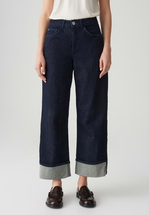 Dark blue wide-leg jeans with a cropped hem, featuring a lighter denim cuff and front pockets, made of sturdy denim fabric.