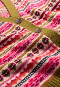 Trikotažna jakna s uzorkom u ružičastim, crvenim i zelenim nijansama, s prednjim kopčanjem i teksturiranom tkaninom.