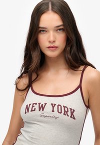 Grauer Tank-Top mit kastanienbraunem Akzent, versehen mit einem "NEW YORK"-Grafik und dem "Superdry"-Logo. Einfaches, tailliertes Design mit dünnen Trägern.