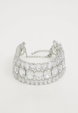Crystal-embellished silver bracelet featuring rectangular and oval stones arranged in a layered design with adjustable chain closure.
