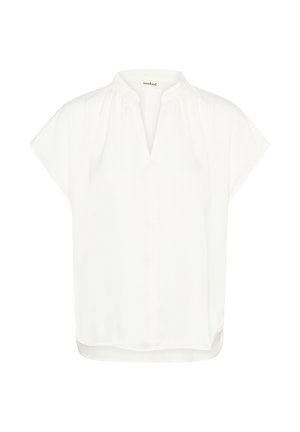 Baltas trumpomis rankovėmis palaidinė su mandarinų apykakle, šiek tiek tekstūruotu audiniu ir laisvu siluetu, su tiesia apačia ir šoninėmis skeltukėmis.