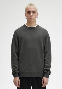 Maglione grigio scuro con scollo a girocollo, polsini e orlo a coste, caratterizzato da un sottile design ricamato a forma di foglia sulla manica sinistra.