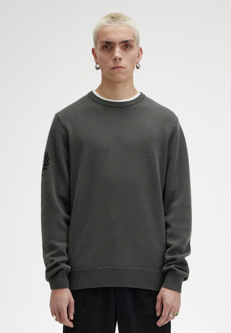 Maglione grigio scuro con scollo a girocollo, polsini e orlo a coste, caratterizzato da un sottile design ricamato a forma di foglia sulla manica sinistra.