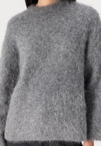 Grauer, flauschiger Pullover aus weichem, texturiertem Stoff, mit Rundhalsausschnitt und lockerer Passform, langen Ärmeln und einem etwas verkürzten Saum.