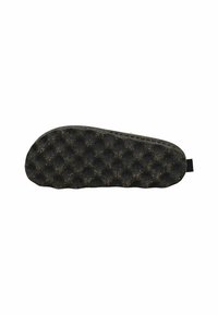 Suela de zapato negra con un patrón texturizado y abultado, y pequeñas manchas marrones, vista desde abajo contra un fondo blanco.
