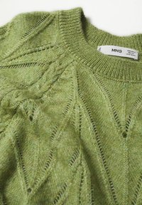 Pull en maille vert clair avec un col rond côtelé et un motif texturé en forme de losange comprenant des détails en maille torsadée.