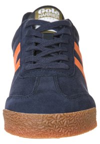 Sneaker blu in suede con strisce arancioni, suola in gomma testurizzata e laccio anteriore. Logo dorato sulla linguetta, caratteristiche di design classico.