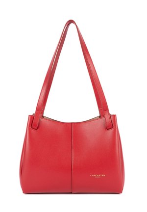Rode Lancaster Paris leren handtas met dubbele schouderriemen en subtiel logo op het rechteronderste voorpaneel.