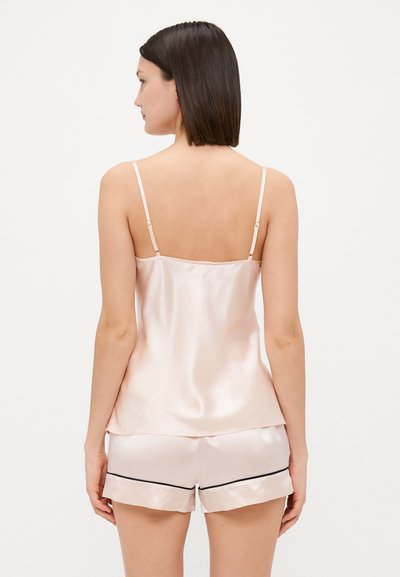 Silky pale pink camisole with thin straps, paired with matching shorts featuring a black trim. Smooth texture and relaxed fit.