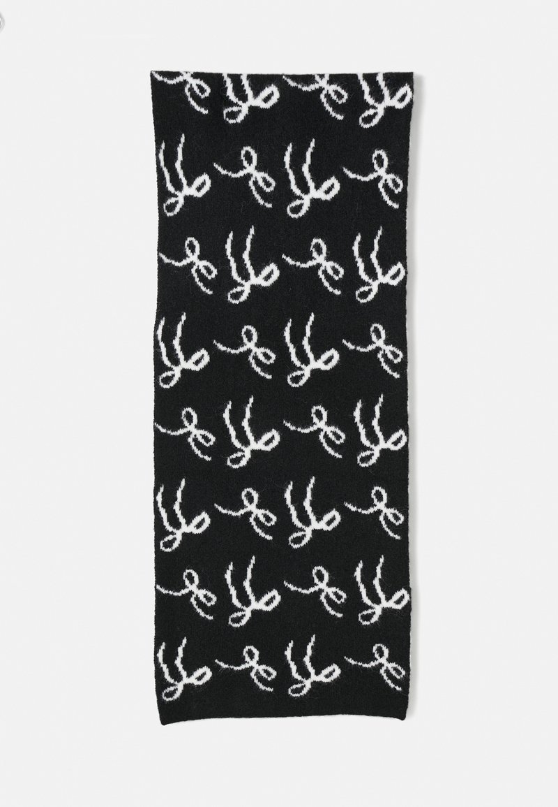 Écharpe noire avec un motif de ciseaux blancs répétés, fabriquée dans un tissu doux avec une finition texturée. Forme rectangulaire, adaptée à divers styles.