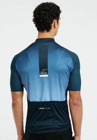 Jersey de ciclismo de manga corta en degradado azul con acentos texturizados en las mangas, bolsillo trasero y detalle del logo en la parte central de la espalda.