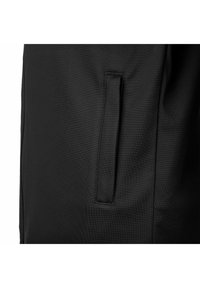 Tessuto nero con una superficie testurizzata; presenta una tasca laterale con apertura orizzontale; linee pulite e design minimalista.