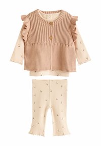 Conjunto de ropa infantil de dos piezas que incluye un cárdigan rosa acanalado con mangas rizadas y botones, combinado con leggings crema con estampados.