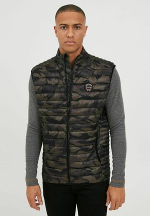 Padded sleeveless vest w kolorze czarnym i zielonym w kamuflażu, z przednim zamkiem i naszywką z logo. Posiada boczne kieszenie oraz wysoki kołnierz.