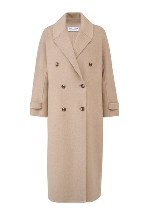 Beige dubbelzijdige jas van wol, met een geknikte kraag, grote knopen en opgerolde mouwen. Recht silhouet en knielengte ontwerp.