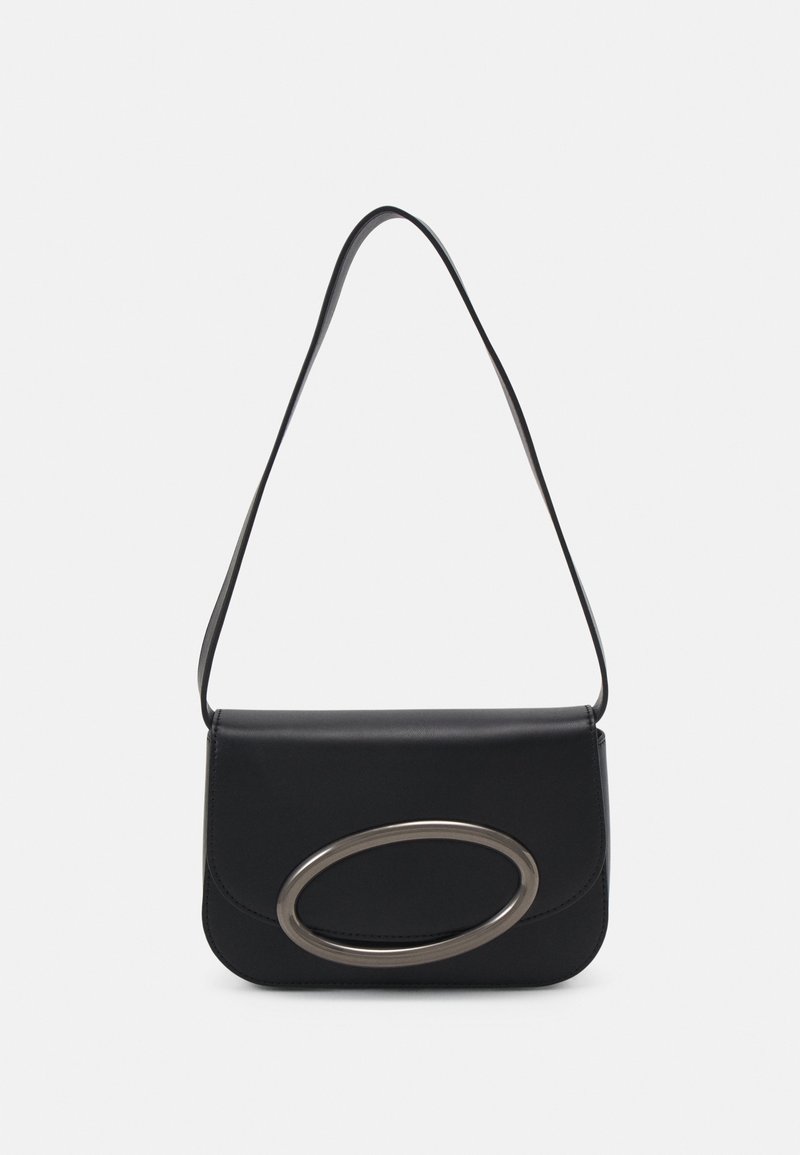 Sac à main en cuir noir avec une texture lisse, une fermeture à rabat et un détail en métal ovale argenté bien visible. Bandoulière ajustable.
