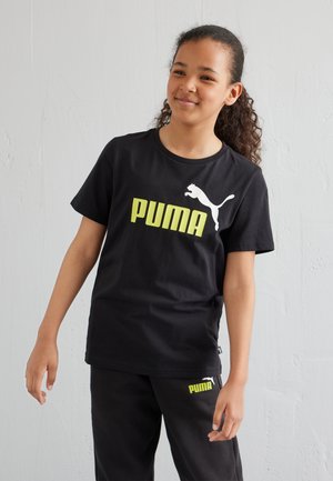 Camiseta de algodón negra con un gran logo blanco de "PUMA" en letras amarillas negritas, escote redondo y mangas cortas.
