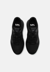 Black athletic shoes featuring a combination of mesh and suede materials, smooth texture, and prominent logo on the tongue, lace-up design.