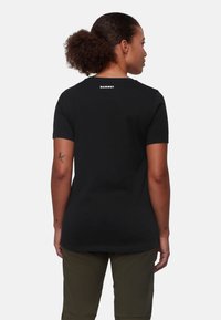 Sort kortærmet T-shirt lavet af bomuld, med rund halsudskæring og "Mammut" logo på ryggen. Glat tekstur og normal pasform.