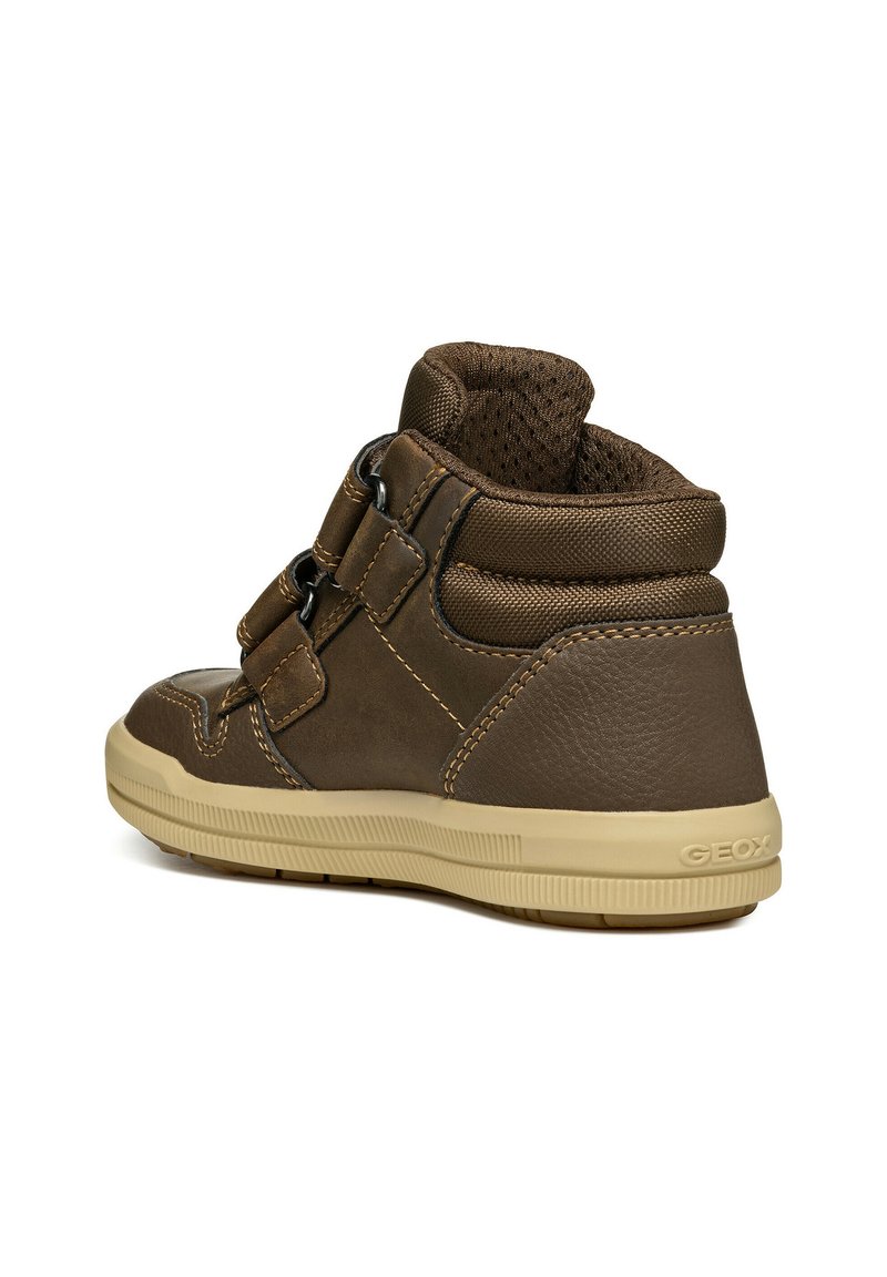 Braune Leder- und synthetische High-Top-Schuhe mit doppelten Klettverschlüssen, strukturiertem Mesh-Futter und einer beigen Gummisohle, die mit Steppnähten verziert ist.