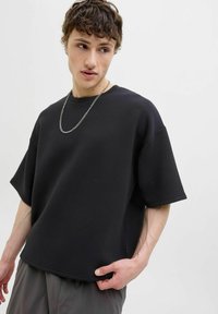 Sort oversized sweatshirt med korte ærmer, lavet af et glat stof. Har en rund halsudskæring og en sømdetalje ved kanten.