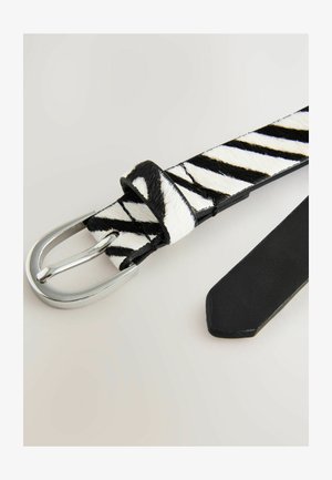 Cinturón de estampado de cebra con diseño texturizado en blanco y negro, hebilla de metal plateado y respaldo de cuero negro liso.