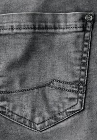 Harmaat farkut, joissa on taka-tasku, jossa on hillitty timanttikuosi, ommeltu tummanharmaalla langalla ja metallisella nappikoristeella.