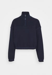Sweatshirt court bleu marine avec un col haut, une demi-fermeture éclair et des poignets élastiqués. Texture douce avec des coutures plates et un minimalisme dans le design.