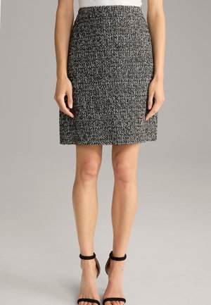 Jupe texturée en noir et blanc avec une coupe droite, à mi-genoux, dotée d'une taille lisse et d'un design en tissu tissé classique.