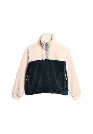 Fleece pullover met hoge kraag, crèmekleurig bovenste deel, donker marineblauw onderste deel en paarse knopenlijst. Voorzien van zijzakken met rits en gele accenten.