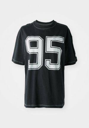 Czarny bawełniany t-shirt z krótkim rękawem, z białym nadrukowanym numerem "95" z przodu i kontrastującymi szwami wzdłuż krawędzi.