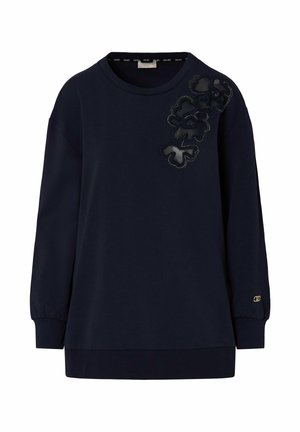 Tumesinine pikkade varrukatega pusa ümar kaelusega ja musta lilleaplikatsiooniga vasakul õlal, soonikkoes mansettide ja äärega.