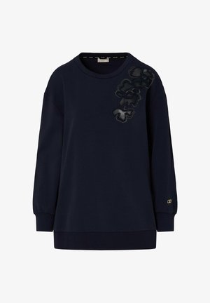 Tamsiai mėlynas džemperis ilgomis rankovėmis su apvaliu iškirpimu ir juoda gėlių aplikacija ant kairiojo peties, ribotais rankogaliais ir apdaila.