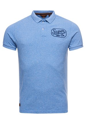 Lichtblauw poloshirt met korte mouwen, twee witte knopen en "Super Dry Co" geborduurd op de linkerborst.
