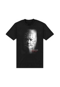 Svart bomull t-shirt med ett grafiskt tryck av ett ansikte med spikar, ”HELLRAISER” text i rött, och en suddig bakgrundseffekt.