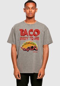 Pilkas per didelis medvilninis marškinėlis su raudonu grafiniu užrašu "TACO DIRTY TO ME" ir Deadpool bei taco iliustracija. Trumpomis rankovėmis, apvalia iškirpte.