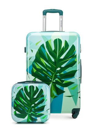 Dos maletas verdes y azules con un diseño abstracto de grandes hojas tropicales, una grande con el asa extendida y una más pequeña adelante.