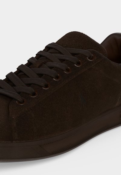 Σκούρο καφέ sneaker από σουέντ με ταιριαστά κορδόνια, μεταλλικά παπούτσια και διακριτικό ανάγλυφο λογότυπο στο πλάι.