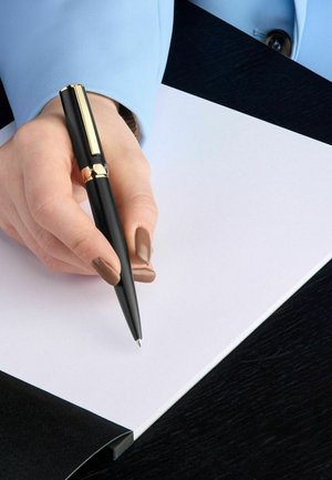Črn pisalo z zlatimi detajli, ki ga drži roka in piše po beli list papirja. Ozadje ima temno površino in svetlo modro rokavico.
