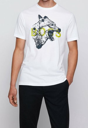 Weißes Baumwoll-T-Shirt mit großem schwarzem Wolf-Motiv und gelbem Schriftzug "DOGS." Kurze Ärmel, Rundhalsausschnitt, lockere Passform.