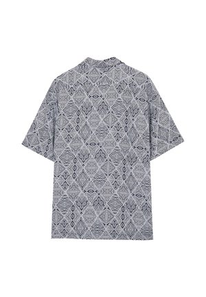 Maglietta a maniche corte di colore blu navy e bianco, con un motivo geometrico composto da forme a diamante e design astratti. Tessuto leggero.