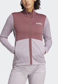 Lagani zip-up kaput u nijansama ružičaste i mauve boje. Ima visoki ovratnik, glatku teksturu i kontrastne blokove boja.